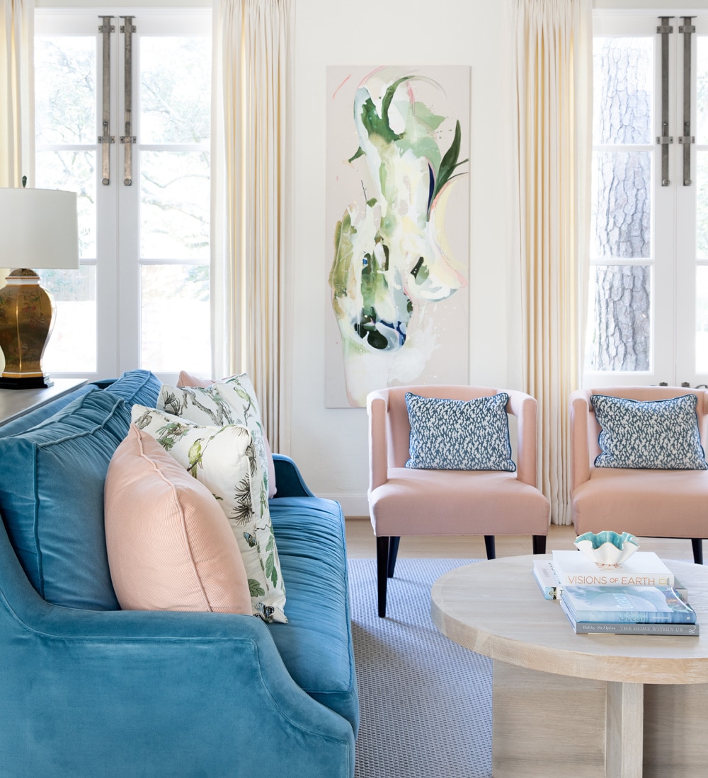 a person sitting in a living room filled with furniture and a window